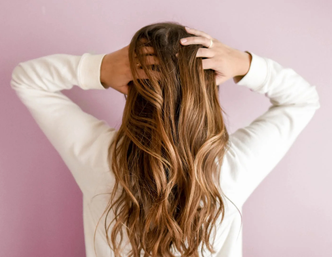 Woman in pink background holding hair